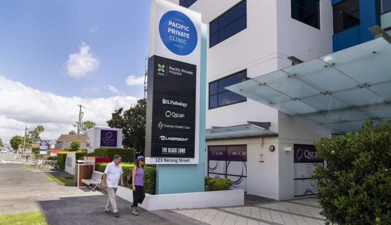 Elderly couple walking in to medical precinct