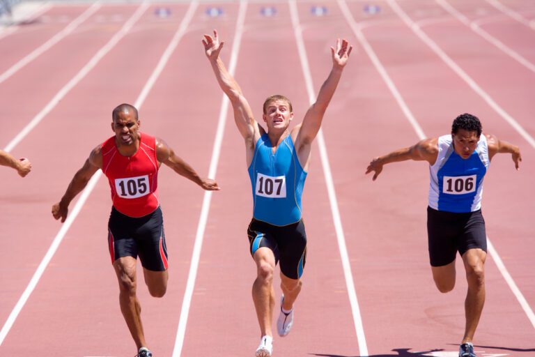 Athletes crossing the finishing line on an athletic track.