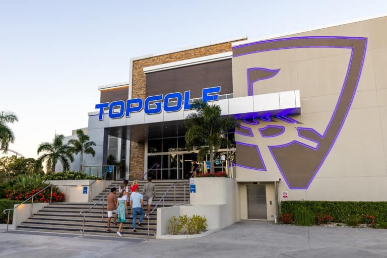 Group of people walking upstairs to the entrance of Top Golf