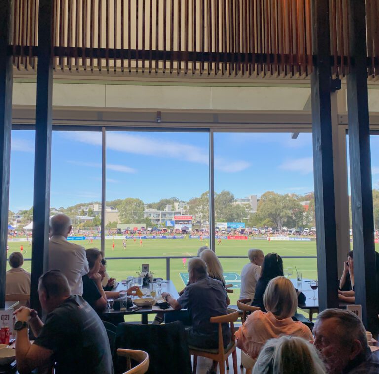 Dinings watching a football match from inside a clubhouse.
