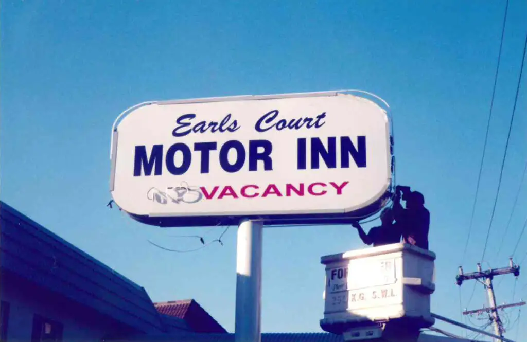 Old Earls Court Motor Inn sign. Blue sky behind.
